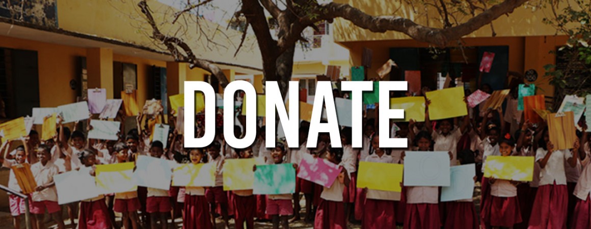 Children holding colorful sheets under a large donate sign