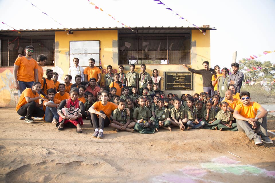 Prayag volunteers and students gathered together outside a school